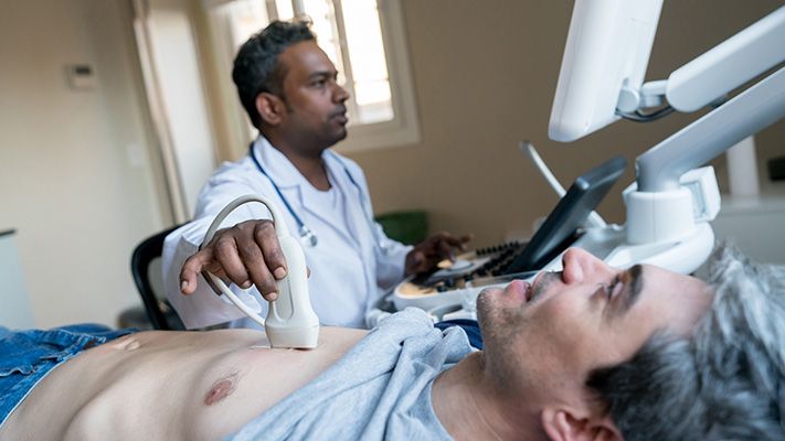 Man laying down while a healthcare practitioner performs a diagnostic test.
